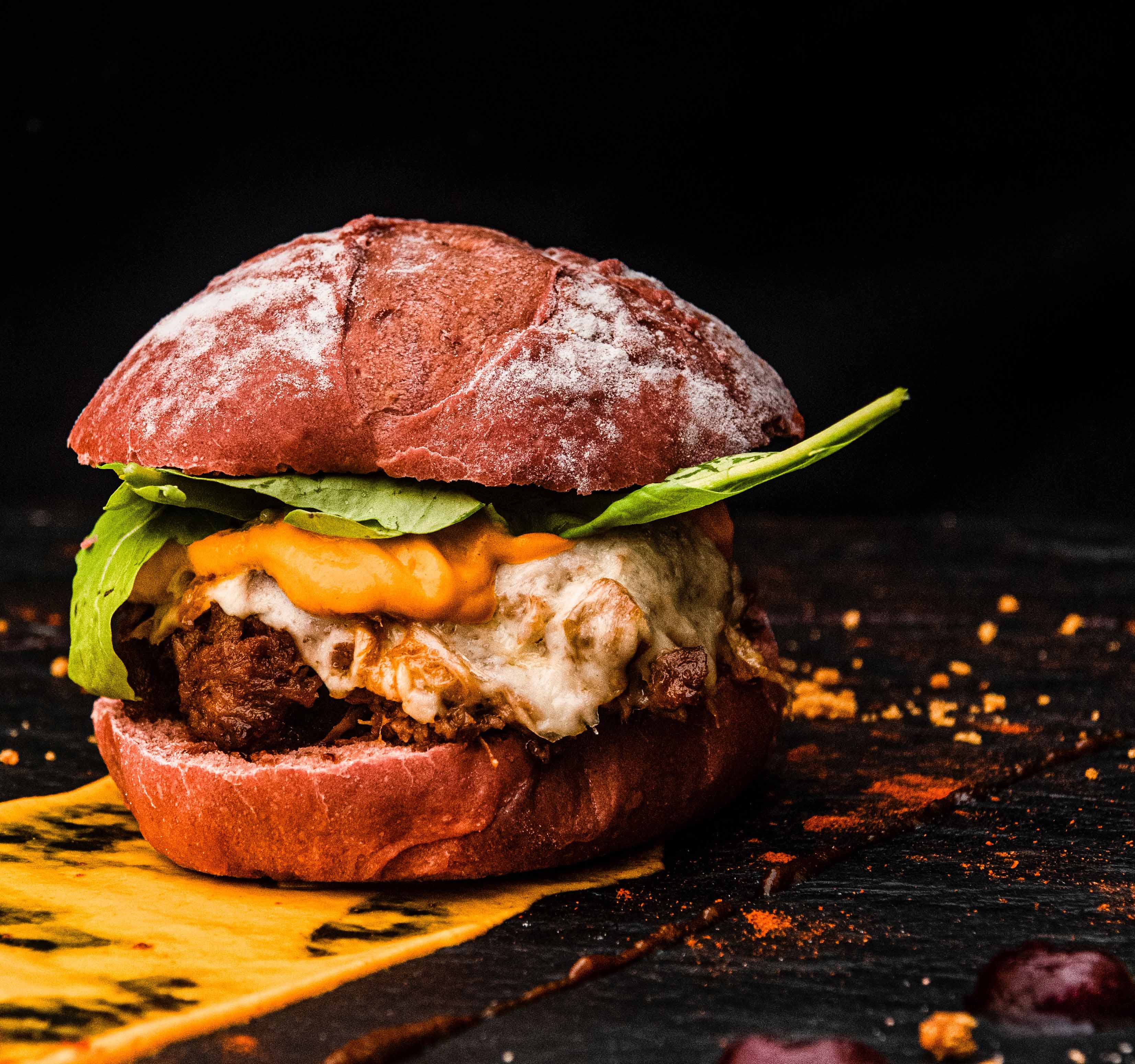 Hamburguesa vegetal con queso vegano, tomate, lechuga y cebolla morada. Pan a base de remolacha